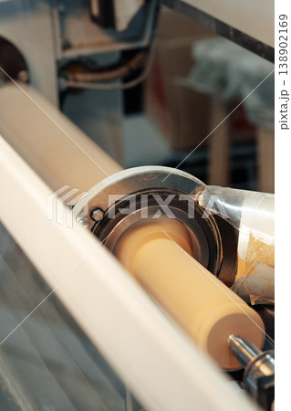 Machine processes dough in a factory during daytime in a busy production environment 138902169