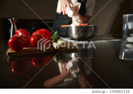 Chef Preparing Dough in Kitchen With Fresh Tomatoes and Spring Onions on Cutting Board 138902316