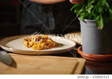 Steaming Homemade Lasagna Served on a Ceramic Plate Next to Fresh Basil Steaming Homemade Lasagna Served on a Ceramic Plate Next to Fresh Basil 138902323