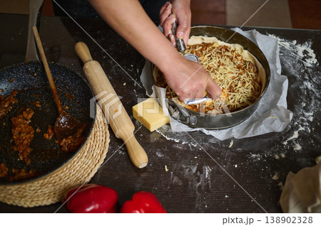 Hands Preparing Homemade Savory Pie With Cheese And Vegetables On Kitchen Counter Hands Preparing Homemade Savory Pie With Cheese And Vegetables On Kitchen Counter 138902328