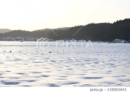 夕日に照らされる雪原と遠くの山並み（福島県猪苗代町） 138902641