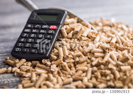 Calculator and Wood Pellets Representing Biomass Fuel Cost, Renewable Energy Budget and Home Heating Expenses 138902915