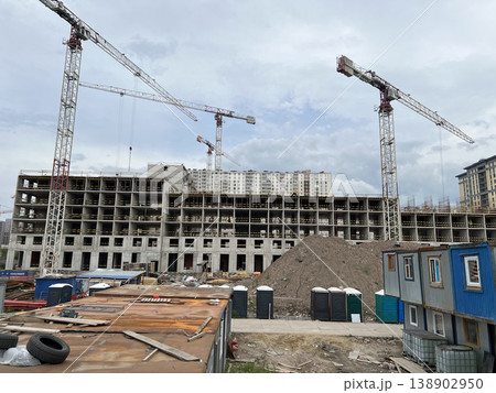 High-Rise Building Under Construction Featuring Site Cabins and Lifting Crane High-Rise Building Under Construction Featuring Site Cabins and Lifting Crane 138902950