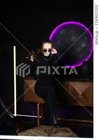 Chic model posing under luminous moonlight in modern studio 138903503