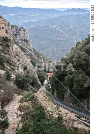 A scenic view of the Montserrat Monastery's funicular railway winding through the rugged mountain landscape in Catalonia, Spain A scenic view of the Montserrat Monastery's funicular railway winding through the rugged mountain landscape in Catalonia, Spain 138903633