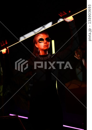 Cinematic portrayal of club goer with reflective eyewear Cinematic portrayal of club goer with reflective eyewear 138903693