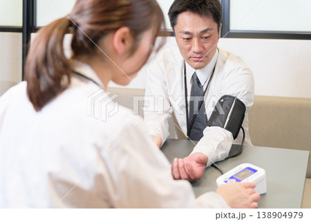 血圧測定を受けるビジネスパーソンの男性 血圧測定を受けるビジネスパーソンの男性 138904979