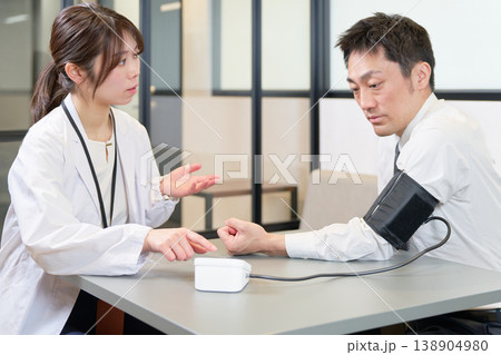 血圧測定を受けるビジネスパーソンの男性 138904980