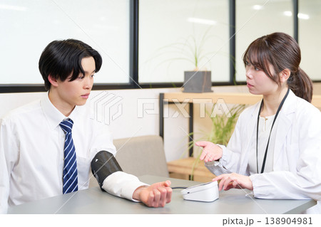 血圧測定を受ける若いビジネスマン 血圧測定を受ける若いビジネスマン 138904981