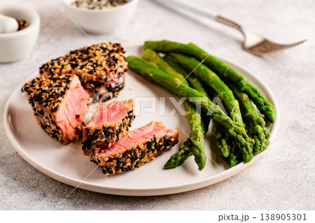 Tuna steak fried in sesame seeds served with asparagus. 138905301