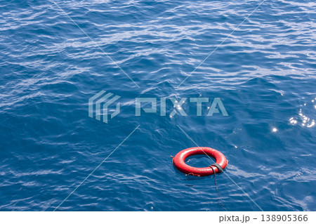 Life preserver floating in calm sea under sunny sky 138905366