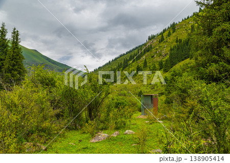 Metal toilet in serene mountain valley under cloudy sky in Kyrgyzstan 138905414