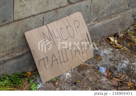 Cardboard sign indicating food waste on urban street written in Kyrgyz meaning dont litter. 138905451