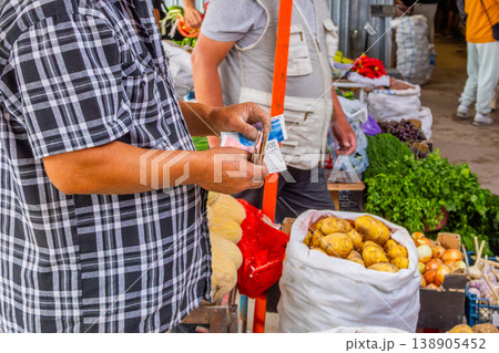 Man Counting Money at Produce Stand in Kyrgyzstan Man Counting Money at Produce Stand in Kyrgyzstan 138905452