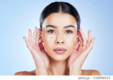 Face, beauty and woman in portrait with skin, natural cosmetics and healthy glow on blue background. Hands, facial and dermatology with spa treatment, skincare and wellness with cosmetic care 138906014