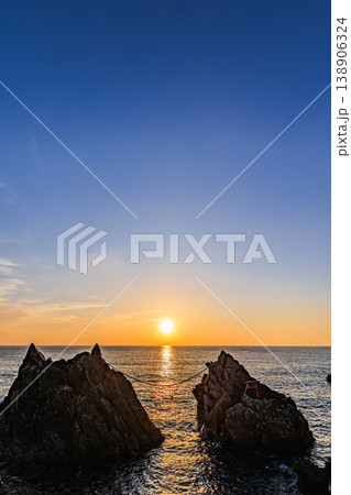 海に沈む夕日と雄龍・雌龍の岩のシルエット 138906324