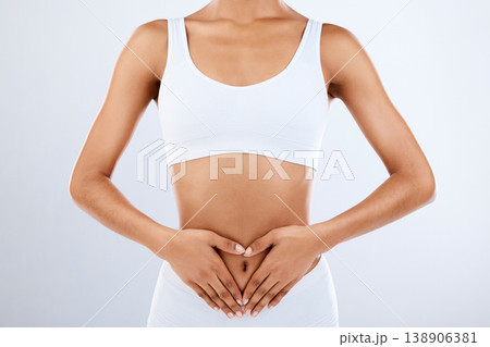 Woman, heart and hands on stomach in studio, diet and holistic gut wellness. Closeup female abdomen, love fingers and belly on background for digestion, balance body and healthy goals to lose weight Woman, heart and hands on stomach in studio, diet and holistic gut wellness. Closeup female abdomen, love fingers and belly on background for digestion, balance body and healthy goals to lose weight 138906381