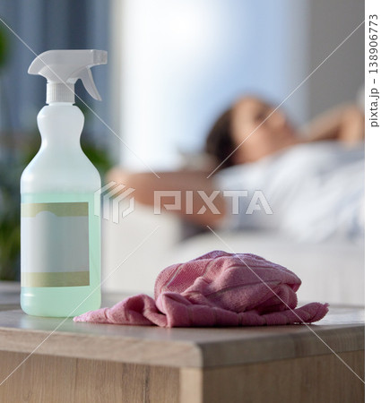 Cleaning, covid or hygiene with supplies in a house with a woman cleaner taking a break in the background. Home, product and housekeeping with a spray, disinfectant or sanitizer for health and safety 138906773