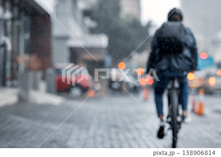 Cyclist, bicycle and delivery in the city on rainy day or cold weather in an urban town on mockup. Biker riding in the rain with cargo, transport or deliver service in a urban town street for courier 138906814