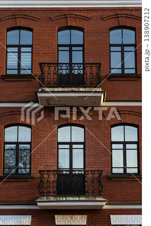 Brick, red facade of an old building with balconies Brick, red facade of an old building with balconies 138907212
