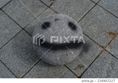 A stone ball with a face painted on it. Smiley face 138907227