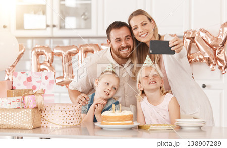 Family birthday party in kitchen, mom photograph on phone camera for social media and mother and father celebrate. Gifts, cake, food and foil balloons at home with dad and twin sisters. 138907289