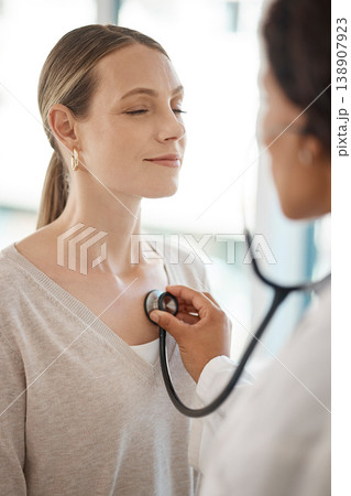 Checking and hearing heart rate with a working doctor consulting the wellness and health of a woman. Clinic checkup with a medical professional and patient at a healthcare center or hospital Checking and hearing heart rate with a working doctor consulting the wellness and health of a woman. Clinic checkup with a medical professional and patient at a healthcare center or hospital 138907923