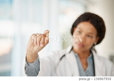 Medical doctor with medicine pills in hand while working in a hospital or clinic. Woman healthcare professional or expert showing oil capsule, vitamin or omega 3 supplement in hospital or pharmacy 138907958