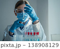 A laboratory scientist in safety gear carefully fills a syringe with a transparent solution for scientific analysis. The scene highlights advanced medical research and biotechnology innovation 138908129