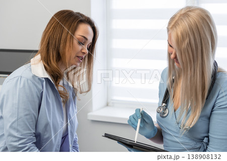 Healthcare professional in white coat, stethoscope discusses medical information with patient, utilizing tablet for digital documentation. Modern medical consultation, technology integration are Healthcare professional in white coat, stethoscope discusses medical information with patient, utilizing tablet for digital documentation. Modern medical consultation, technology integration are 138908132
