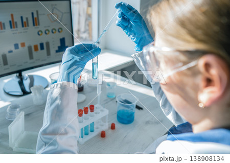 A researcher carefully transfers liquid between test tubes, focusing on scientific analysis in a bright laboratory. Advanced technology and colorful chemicals highlight innovative research A researcher carefully transfers liquid between test tubes, focusing on scientific analysis in a bright laboratory. Advanced technology and colorful chemicals highlight innovative research 138908134