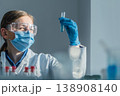 A researcher wearing gloves, goggles, and a face mask analyzes a chemical sample in a test tube. The laboratory setting emphasizes safety, innovation, and scientific discovery 138908140