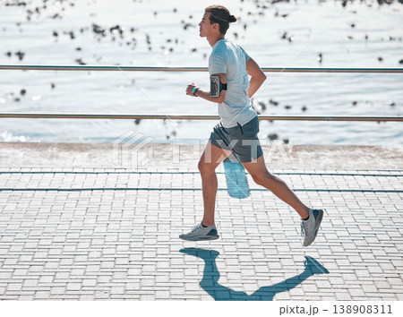 Cardio, fitness and man running on the promenade for training, health and workout by the beach. Exercise, sports and runner by the sea in the morning for jogging and outdoor sports for motivation Cardio, fitness and man running on the promenade for training, health and workout by the beach. Exercise, sports and runner by the sea in the morning for jogging and outdoor sports for motivation 138908311