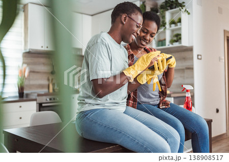 Two cheerful young women taking a break from cleaning the kitchen and looking at the phone Two cheerful young women taking a break from cleaning the kitchen and looking at the phone 138908517