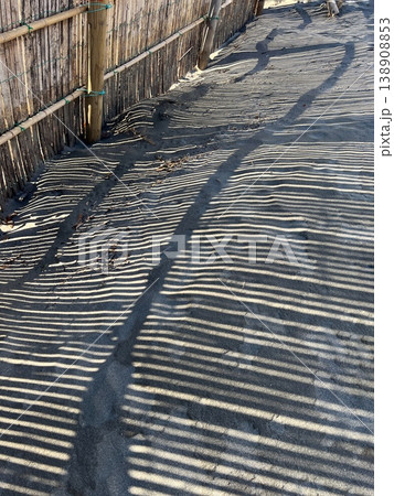 砂浜に映る防砂柵の影、海岸に設置された竹製防砂柵の芸術的なシルエット、防砂柵のシルエット 138908853