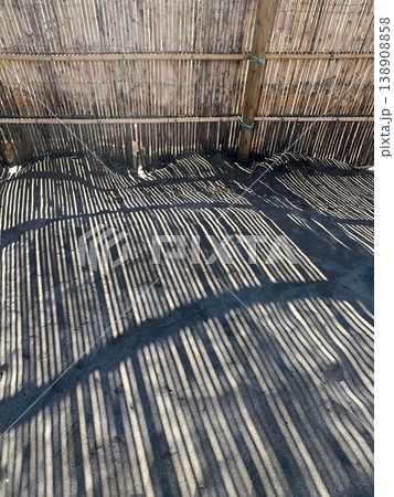 砂浜に映る防砂柵の影、海岸に設置された竹製防砂柵の芸術的なシルエット、防砂柵のシルエット 138908858