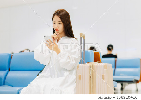 空港で出発までロビーでくつろぐ女性 「撮影協力:関西国際空港(KIX)」 空港で出発までロビーでくつろぐ女性 「撮影協力:関西国際空港(KIX)」 138910416
