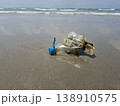 Ocean's Unwanted Guest: A weathered plastic bottle lies stranded on the sandy shore, a stark reminder of environmental pollution and the urgent need for conservation. 138910575