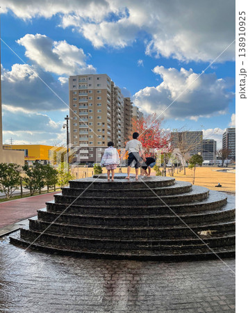 噴水の段差で遊ぶ子どもたちと冬の青空が広がる都市公園風景 噴水の段差で遊ぶ子どもたちと冬の青空が広がる都市公園風景 138910925