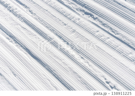 Bright winter ski trail. White striped ski run with tranquil morning shadows and calm ambiance Bright winter ski trail. White striped ski run with tranquil morning shadows and calm ambiance 138911225