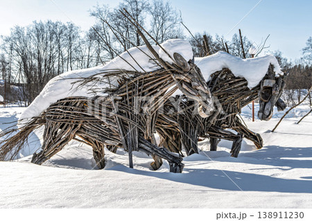 Wooden stick sculptures of running horses covered with winter snow 138911230