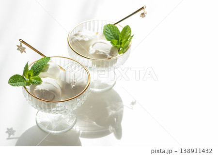 Vanilla Ice Cream in Elegant Glass Bowls on White Table with Sunlight 138911432