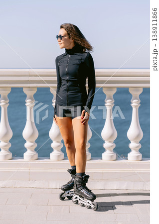 Woman in sportswear on roller skates by seaside promenade 138911866