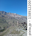 Kurta and Taga signal tower ruins, North Ossetia, Russia. Broken medieval watchtower walls with Caucasus Mountains in the background 138912200