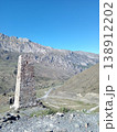 Kurta and Taga tower remains, North Ossetia, Russia. Historic signal tower ruins standing against a backdrop of Caucasus peaks under a bright sky 138912202