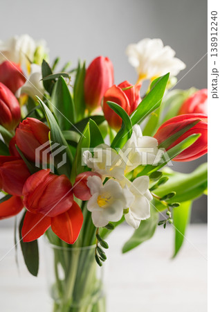 Spring floral background. Red tulips and Fresia white flower bouquet. Copy space 138912240