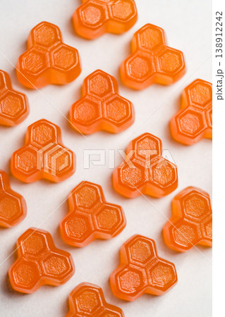 Orange vitamins jelly gummies on bright background, food supplements, top view 138912242