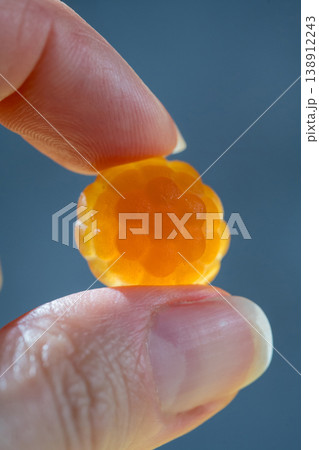 Food supplements. Vitamins jelly gummies fruit orange raspberry shaped in a female hands, close-up Food supplements. Vitamins jelly gummies fruit orange raspberry shaped in a female hands, close-up 138912243
