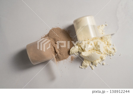 Vanilla and chocolate whey protein powder in scoops, food supplements, bright background 138912244