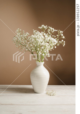 White floral background. Soft home decor, vase with white small flowers on white background. 138912257